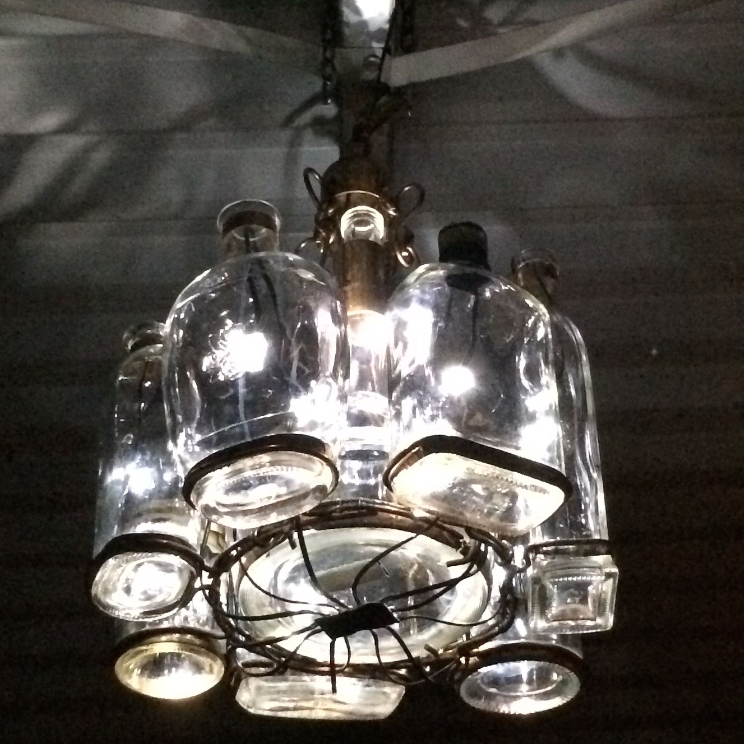 The Bluetooth-controlled, dimmable LED hand-built bourbon bottle chandelier at Halcyon